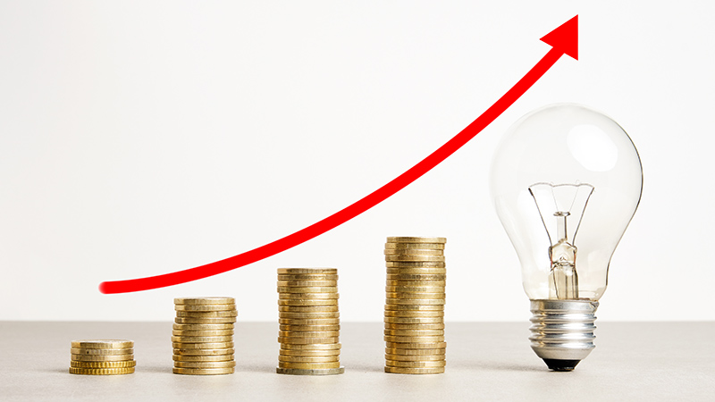 Subida de los costes regulados de la electricidad - monedas - grafico ascendente - bombilla